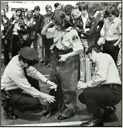 Police Explorer Career Scout being fitted with protective leather garb used in working with police dogs      Click for Larger Image